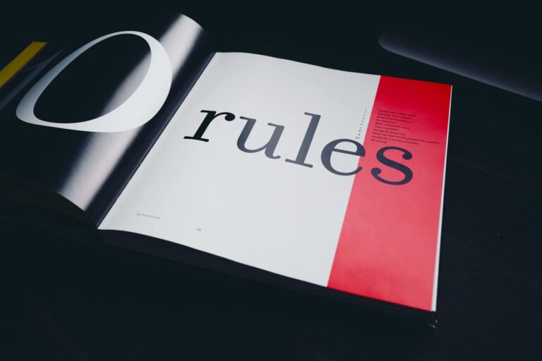 Close-up of an open book page featuring the word 'rules' with a black background.